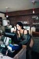 A woman sitting at a counter talking on a cell phone.